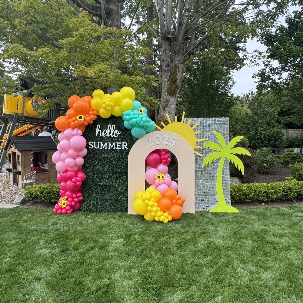 Bright Hello Summer arched backdrop with pink, yellow, orange, and teal balloons
